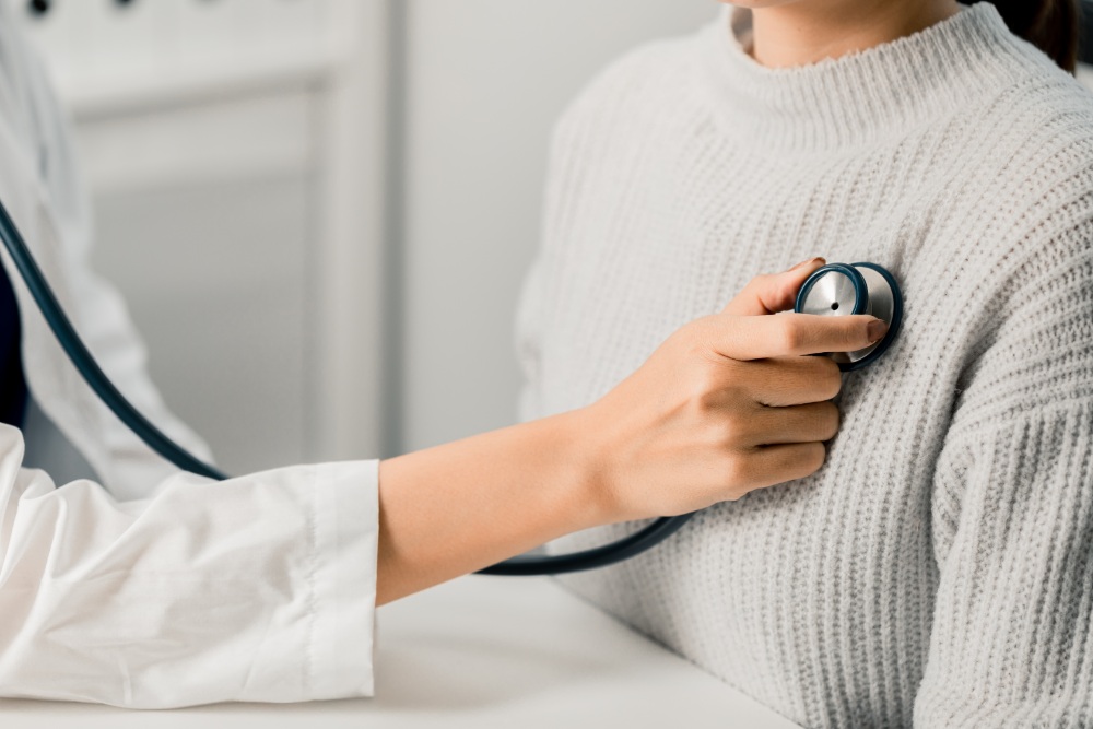 Doctor using stethoscope on patient